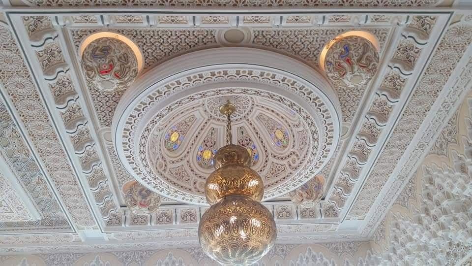 Plafond sculpté entourant un luminaire marocain