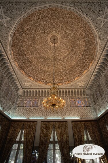 Chambre marocaine avec plafond sculpté et lustre traditionnel