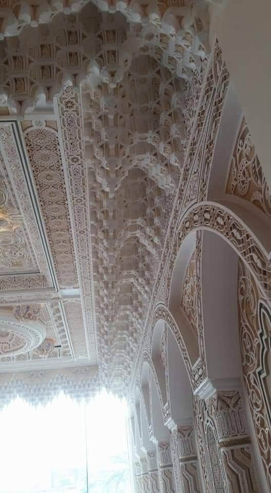 Couloir orné d’arches et de muqarnas en plâtre blanc